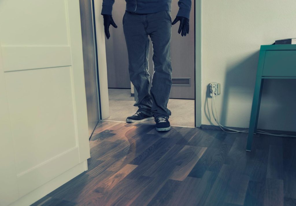 Unidentified man entering apartment, potential security risk.
