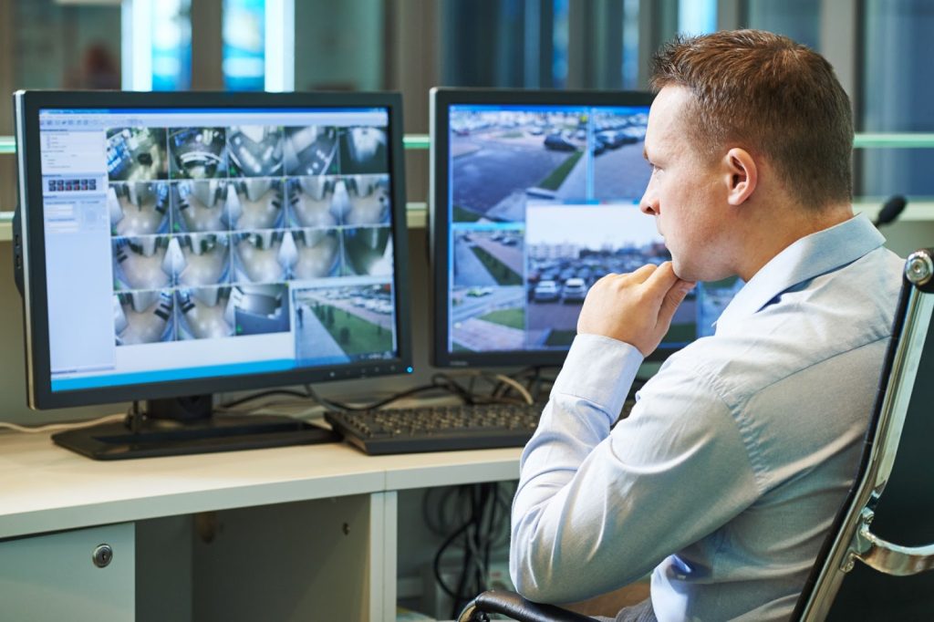 Security personnel monitoring live surveillance footage from shopping center cameras.