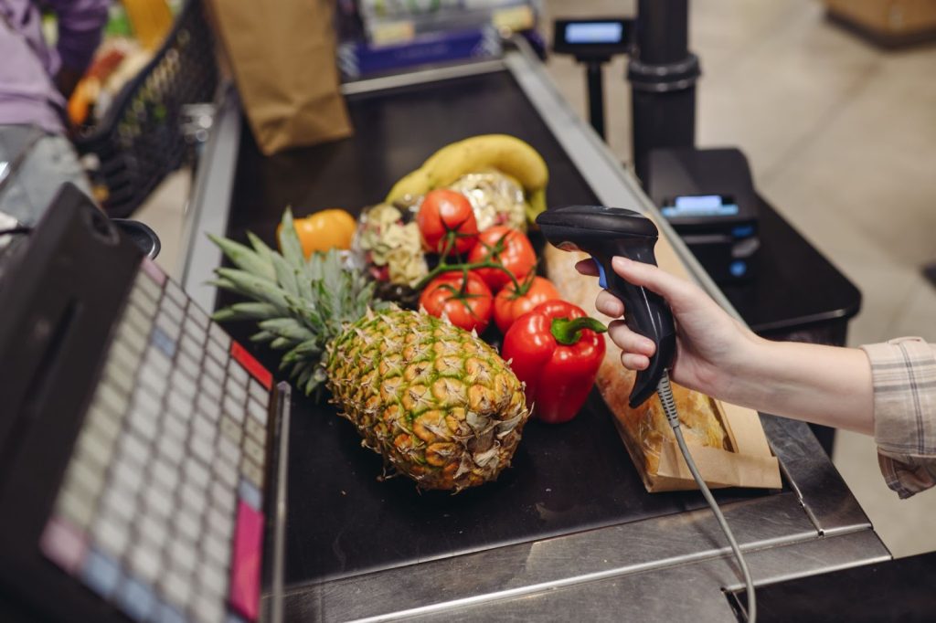 Cashier scanning items at a grocery store checkout.