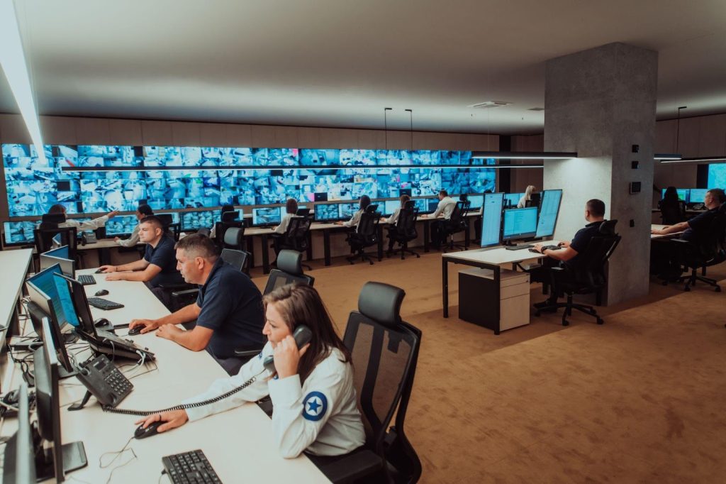 Operators in a security monitoring center overseeing multiple screens, exemplifying proactive surveillance.