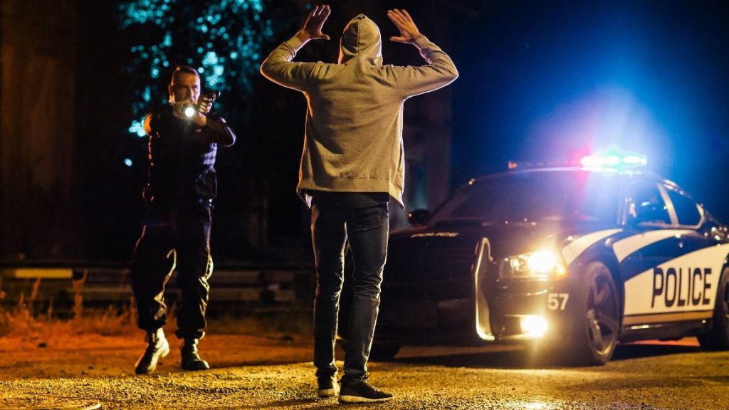 Officier de police détenant un suspect la nuit.