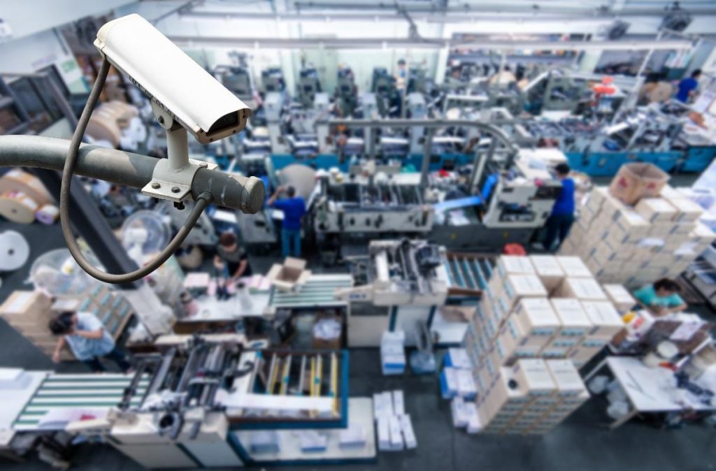 Caméra de sécurité surveillant le sol d'une usine.