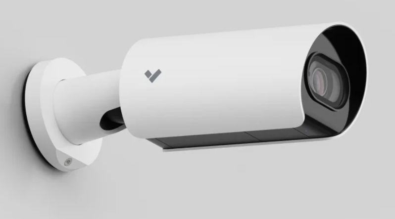 White bullet security camera mounted on a wall.