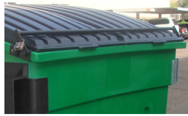 Benne à ordures verte fermée avec cadenas sur le parking.