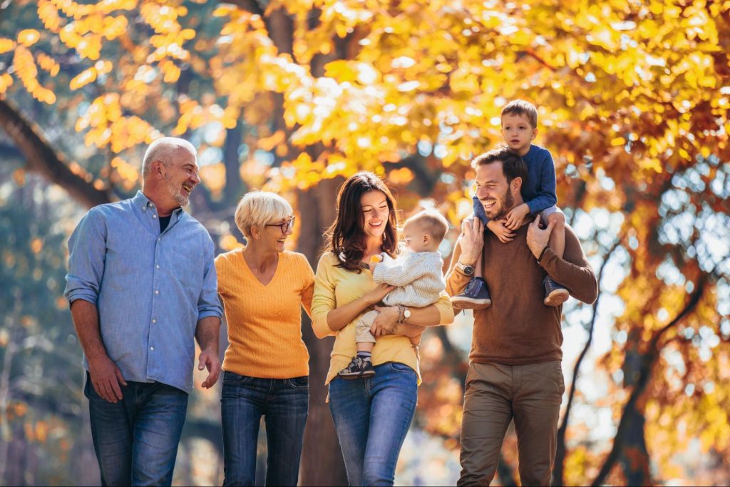 Famille avec grands-parents et enfants profitant de l'automne dans un parc en Caroline du Nord.