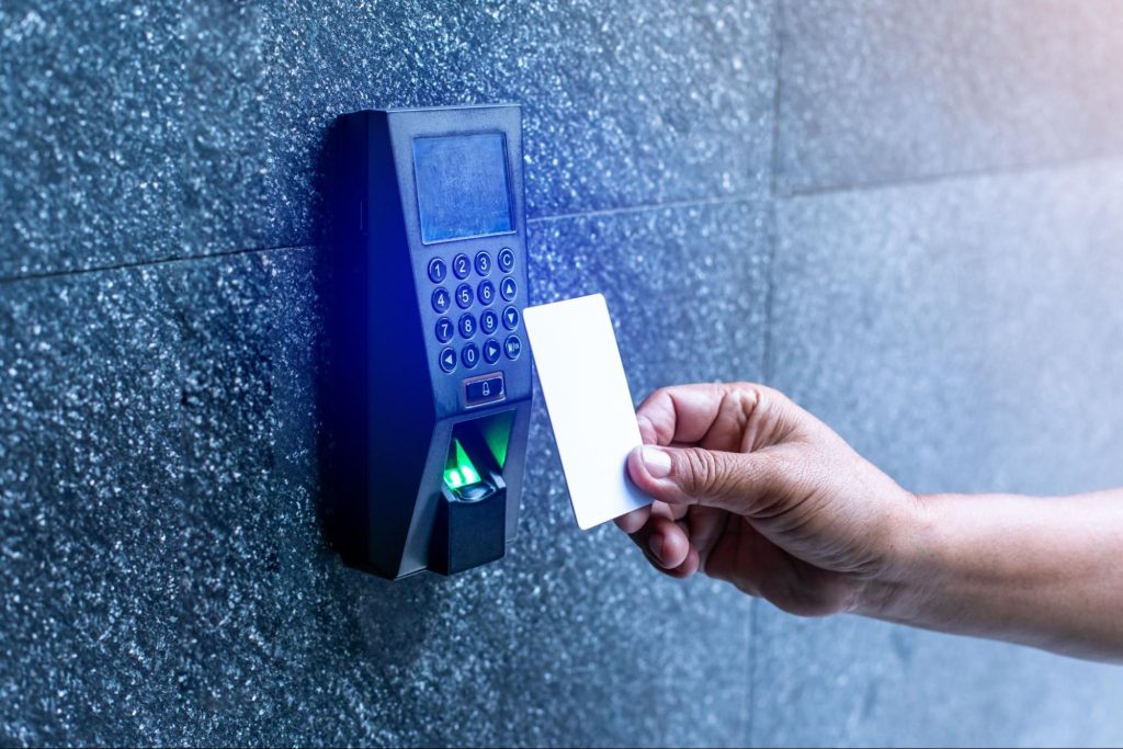 Hand holding a card to a reader on a high-security access control system.