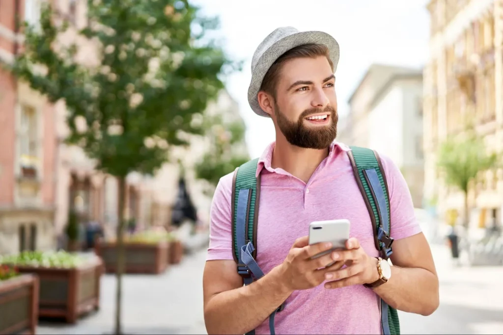 Man securely using smartphone in urban area, representing personal safety measures.