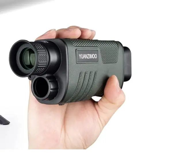 Hand holding a compact night vision monocular with dual lenses, used for low-light and nighttime visibility.