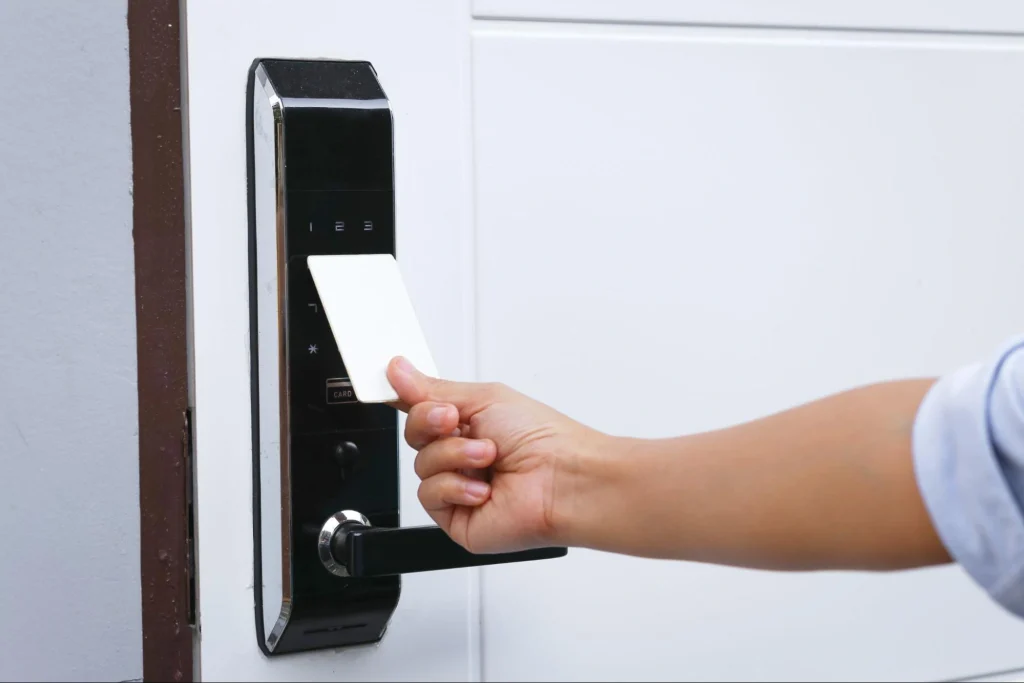 Employee using a proximity card on a card reader for building access control.