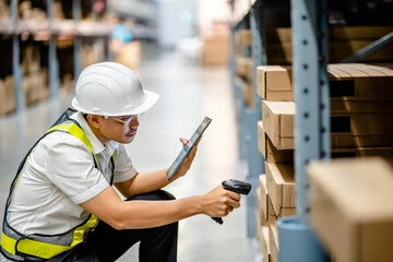 Warehouse worker scanning boxes to update inventory records and reduce shrinkage