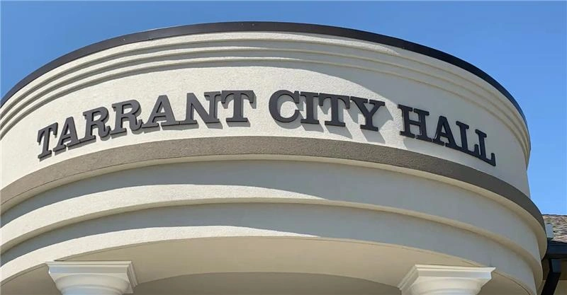 Vue de face du bâtiment de l'hôtel de ville de Tarrant sous un ciel dégagé, représentant l'une des villes dangereuses de l'Alabama 2025.