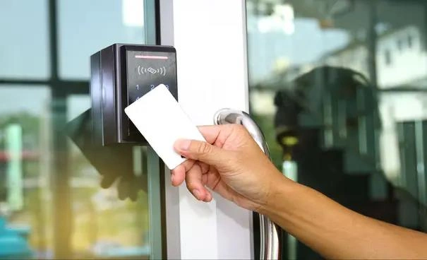 Personne utilisant une carte d'accès RFID pour déverrouiller une porte sécurisée, améliorant ainsi la sécurité de la cour de triage.