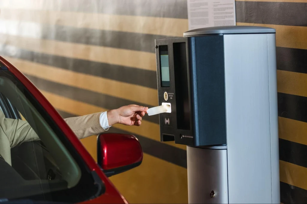 Conducteur utilisant un système de contrôle d'accès par badge pour entrer dans le parking.