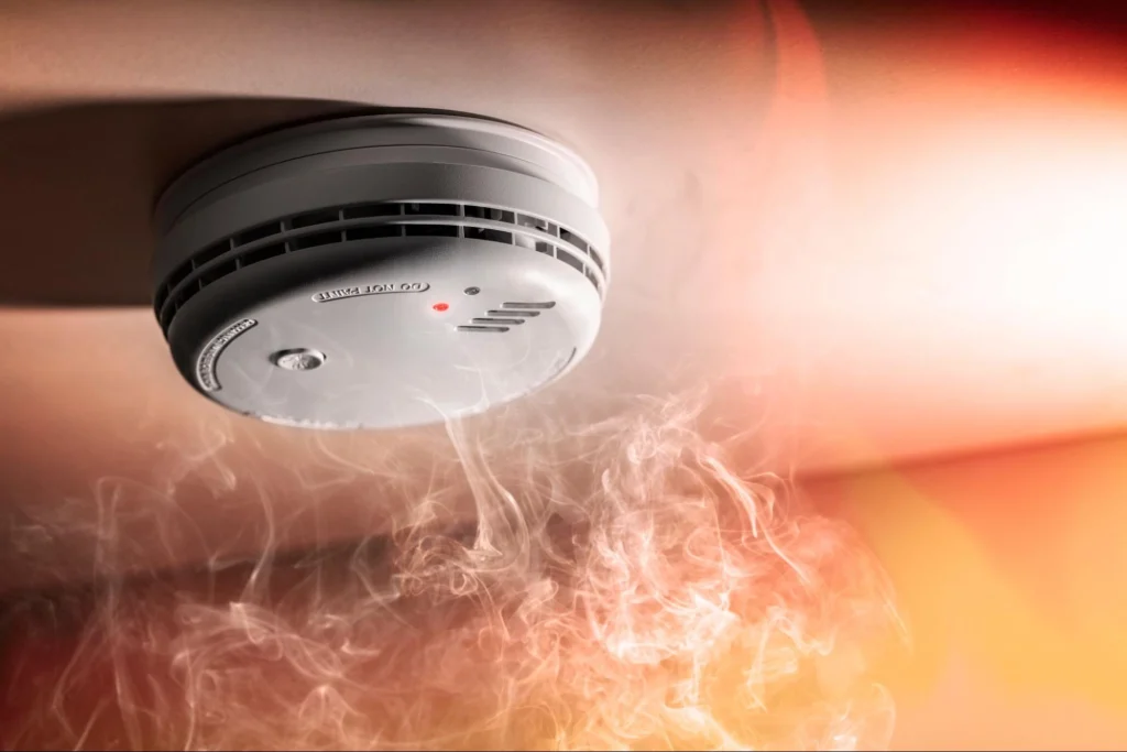 Smoke detector activating during fire emergency in school safety system.
