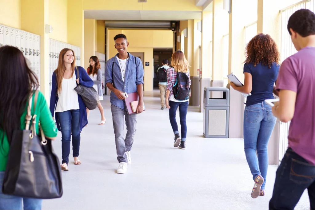 Students walking in a school hallway showing a safe and active campus environment.